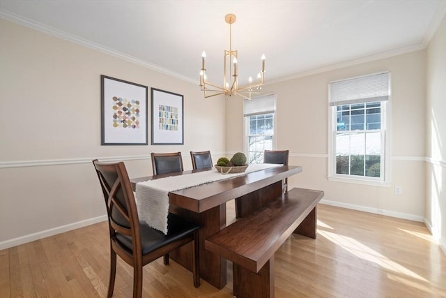 dining space with light wood finished floors, baseboards, ornamental molding, and an inviting chandelier