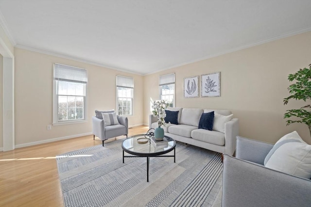 living room with light wood-style floors, crown molding, and baseboards