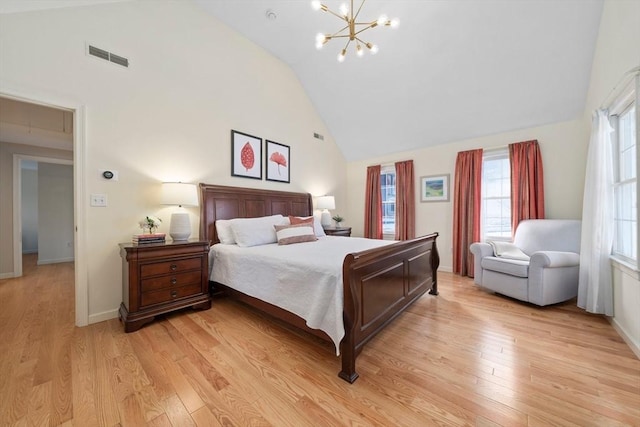 bedroom with high vaulted ceiling, light wood-style flooring, visible vents, and a notable chandelier