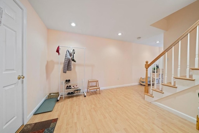 exercise room with baseboards, wood finished floors, and recessed lighting