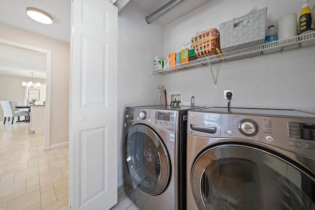 laundry area with washer and dryer, laundry area, a notable chandelier, and baseboards