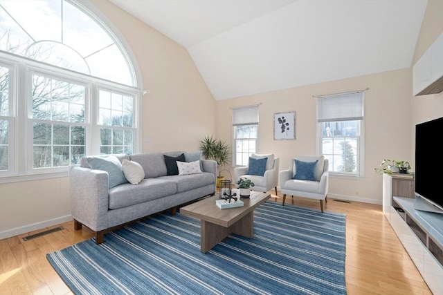 living room with lofted ceiling, visible vents, light wood-style flooring, and baseboards