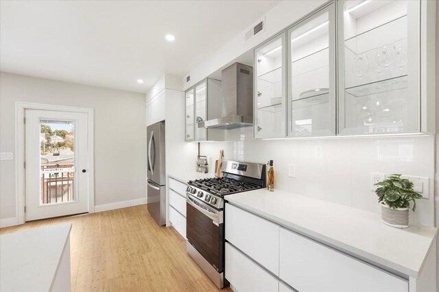 86 Cypress St Unit 8-6, Watertown, MA 02472 - kitchen with appliances with stainless steel finishes, wall chimney exhaust hood, white cabinets, light wood-style flooring, and modern cabinets