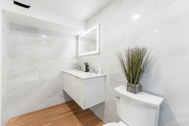 86 Cypress St Unit 8-6, Watertown, MA 02472 - bathroom featuring toilet, vanity, tile walls, and wood finished floors