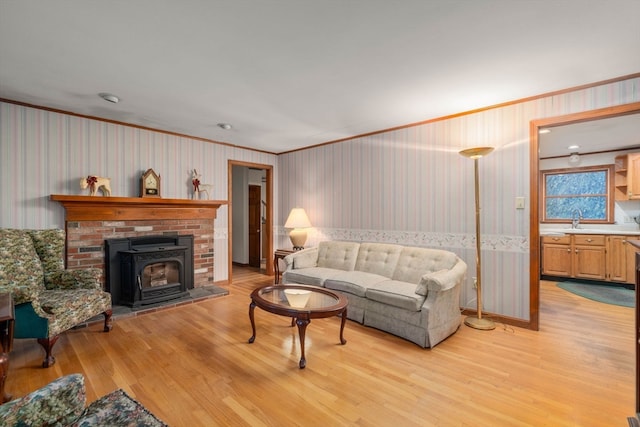 living room featuring ornamental molding, light hardwood / wood-style flooring, and sink