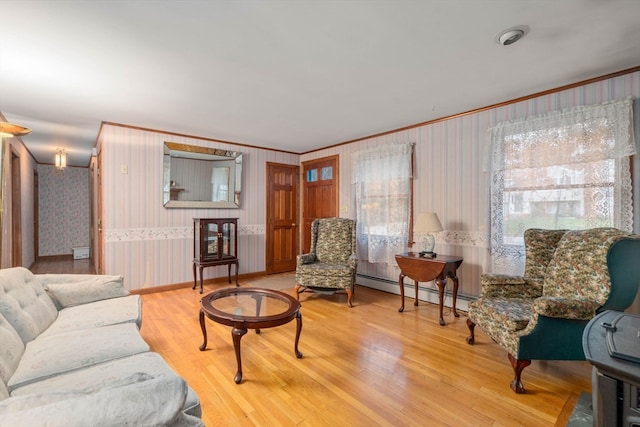 living room with hardwood / wood-style floors, a baseboard heating unit, and ornamental molding