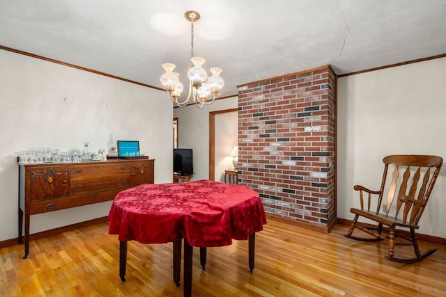 dining area with an inviting chandelier, light wood-type flooring, and ornamental molding