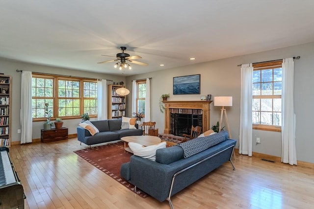 living area featuring light wood finished floors, a fireplace, a ceiling fan, recessed lighting, and visible vents