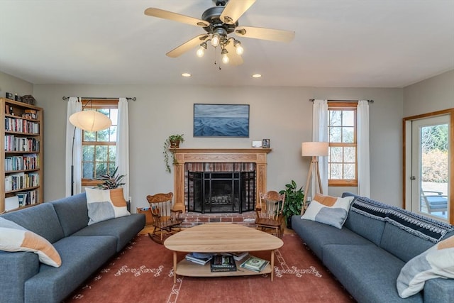 living room featuring a brick fireplace, recessed lighting, and a ceiling fan
