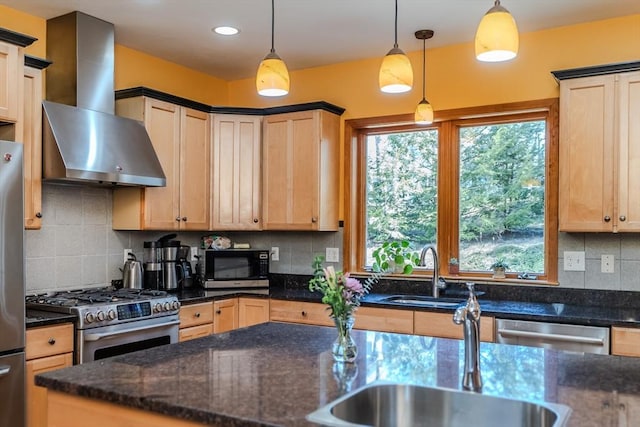 kitchen with light brown cabinetry, a healthy amount of sunlight, wall chimney exhaust hood, a sink, and stainless steel appliances
