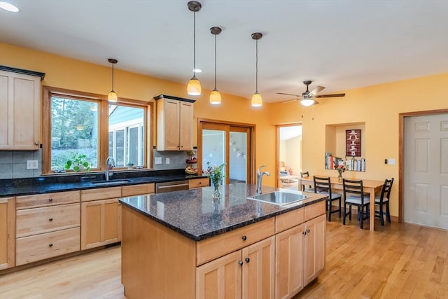 kitchen with a sink, light wood-style flooring, light brown cabinetry, and dishwasher