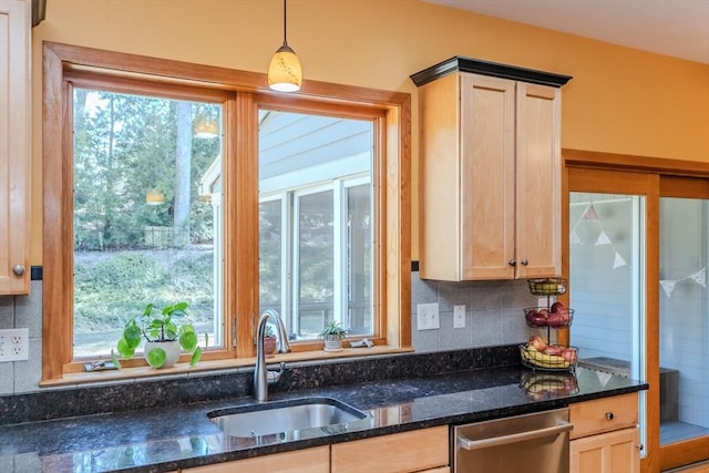 kitchen with light brown cabinetry, a sink, dishwasher, dark stone counters, and decorative backsplash