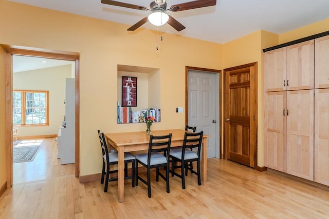 dining area featuring a ceiling fan, baseboards, and light wood-style floors