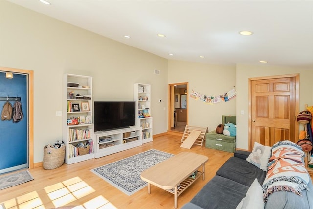 living room with recessed lighting, baseboards, wood finished floors, and vaulted ceiling