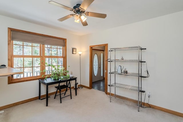 carpeted office featuring a ceiling fan and baseboards