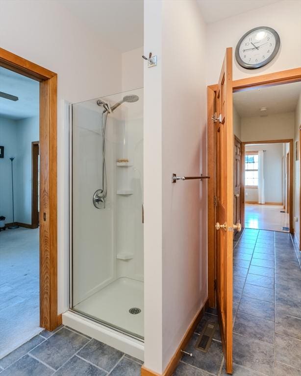full bath with baseboards and a shower stall