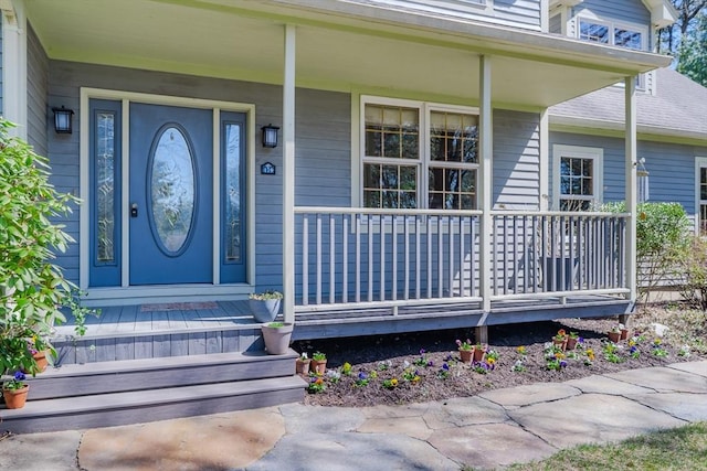 view of exterior entry featuring covered porch