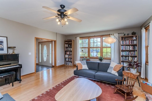 living room with baseboards, a ceiling fan, and wood finished floors