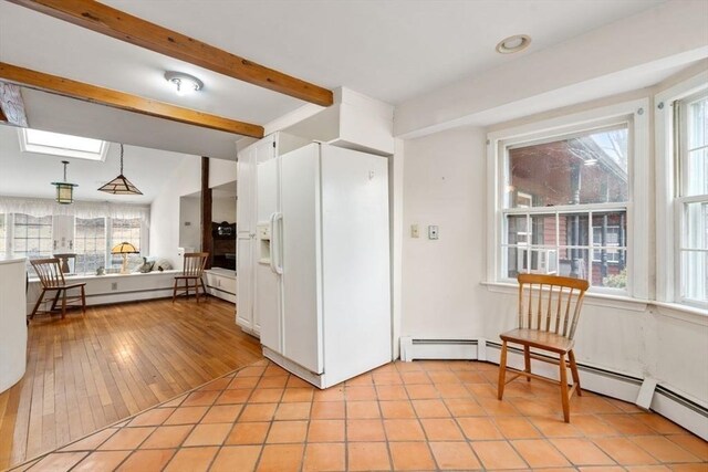 kitchen featuring white cabinets, a baseboard radiator, beam ceiling, white refrigerator with ice dispenser, and light tile patterned floors