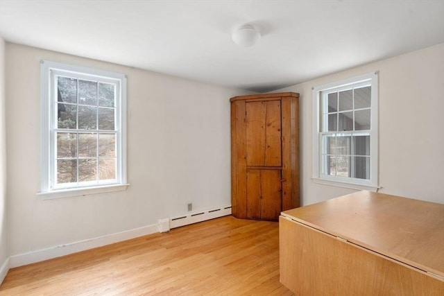 interior space featuring baseboards, light wood-type flooring, and a baseboard radiator