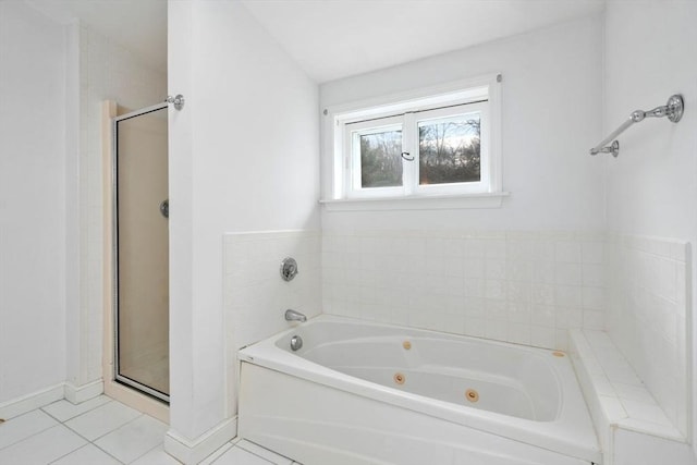 bathroom with tile patterned flooring, a jetted tub, baseboards, and a shower stall