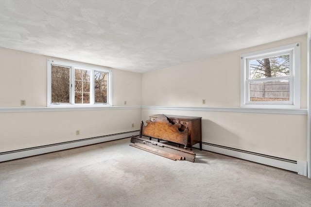 carpeted spare room with a textured ceiling and baseboard heating