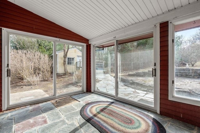 unfurnished sunroom featuring stone finish floor, lofted ceiling, and wooden ceiling