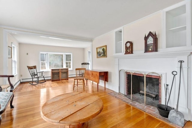 living area featuring a fireplace, wood finished floors, and ornamental molding