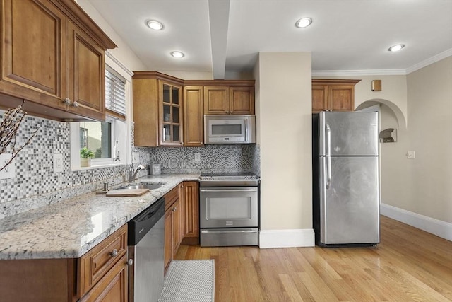 28 Mason, Salem, MA 01970 - kitchen featuring appliances with stainless steel finishes, a sink, brown cabinets, baseboards, and light stone counters