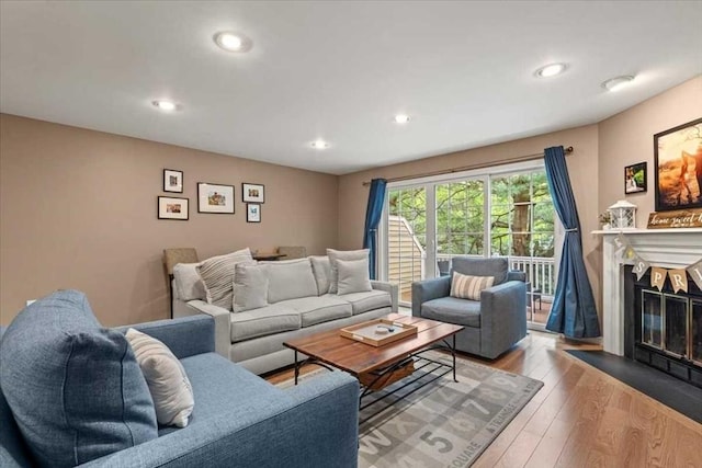 living area featuring a fireplace with flush hearth, recessed lighting, and hardwood / wood-style flooring