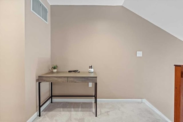 office space featuring light carpet, lofted ceiling, and baseboards