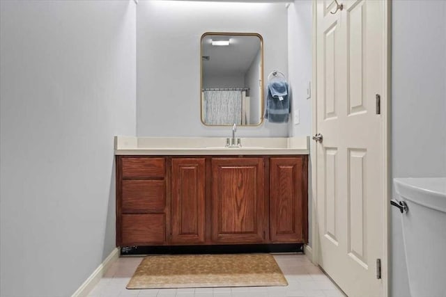 bathroom with vanity, tile patterned flooring, and baseboards