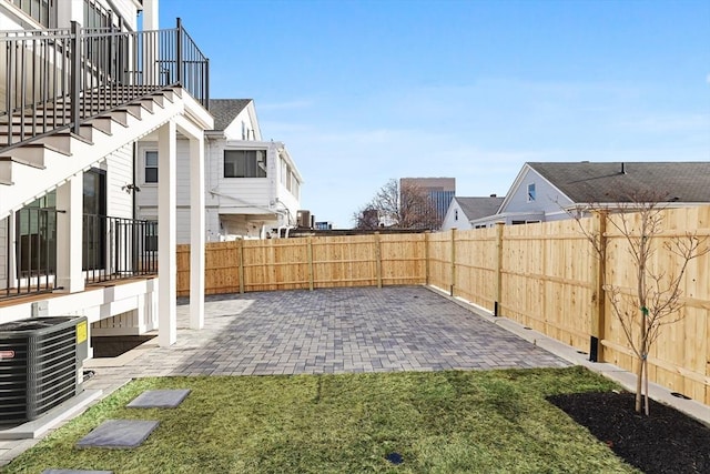 view of yard with central AC and a patio