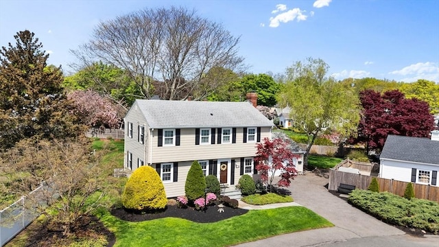 10 Dearborn Ln, Salem, MA 01970 - view of front facade with a chimney, fence, roof with shingles, and asphalt driveway