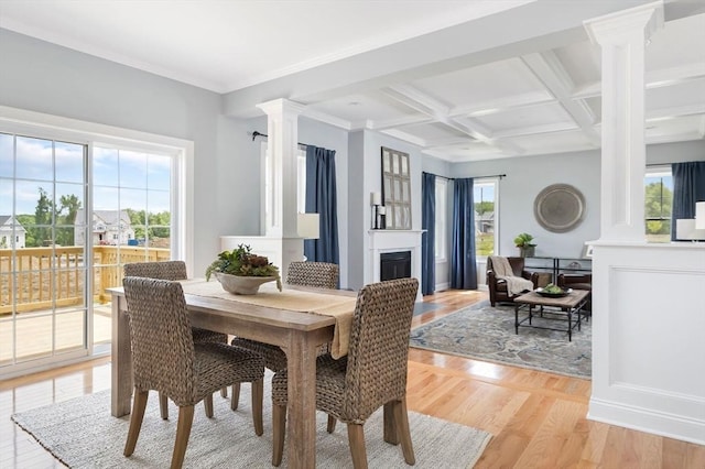 dining area with decorative columns, coffered ceiling, beamed ceiling, and light hardwood / wood-style flooring