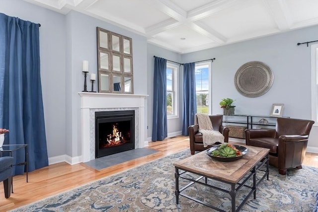 living room with coffered ceiling, hardwood / wood-style flooring, a high end fireplace, and beam ceiling