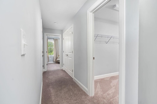 hall featuring dark colored carpet