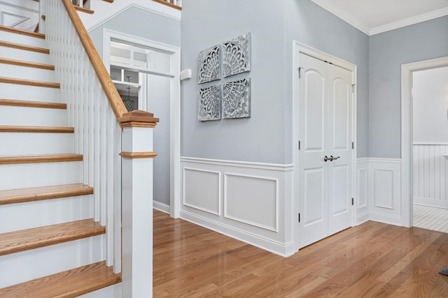 staircase with hardwood / wood-style flooring and ornamental molding