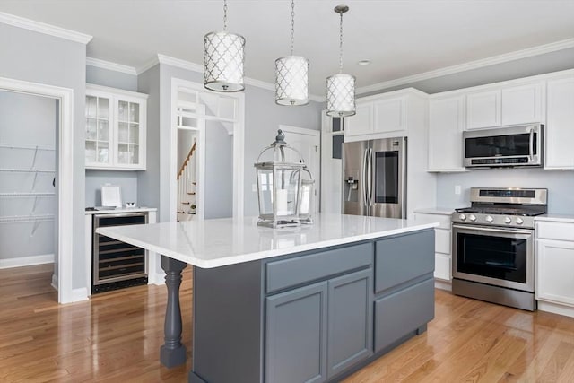 kitchen with gray cabinetry, white cabinetry, a center island with sink, and appliances with stainless steel finishes