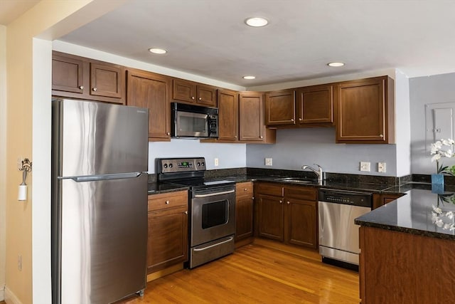 44 Lafayette Ave Unit 404, Chelsea, MA 02150 - kitchen featuring appliances with stainless steel finishes, a sink, light wood finished floors, recessed lighting, and dark stone counters