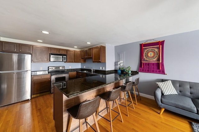 44 Lafayette Ave Unit 404, Chelsea, MA 02150 - kitchen with stainless steel appliances, a peninsula, a breakfast bar, light wood-style floors, and recessed lighting