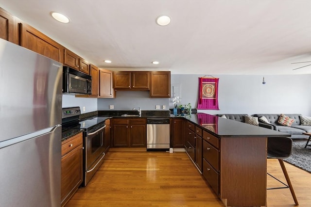 44 Lafayette Ave Unit 404, Chelsea, MA 02150 - kitchen with stainless steel appliances, a sink, a kitchen breakfast bar, open floor plan, and a peninsula