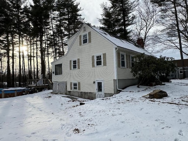 view of snowy exterior with a wooden deck