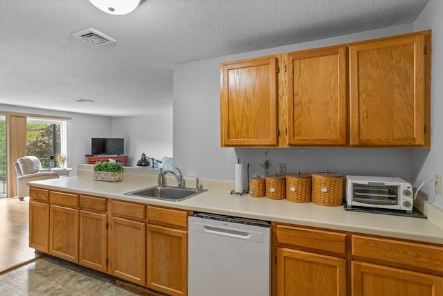 181 Littleton Rd Unit 333, Chelmsford, MA 01824 - kitchen featuring dishwashing machine, a sink, open floor plan, light countertops, and a textured ceiling