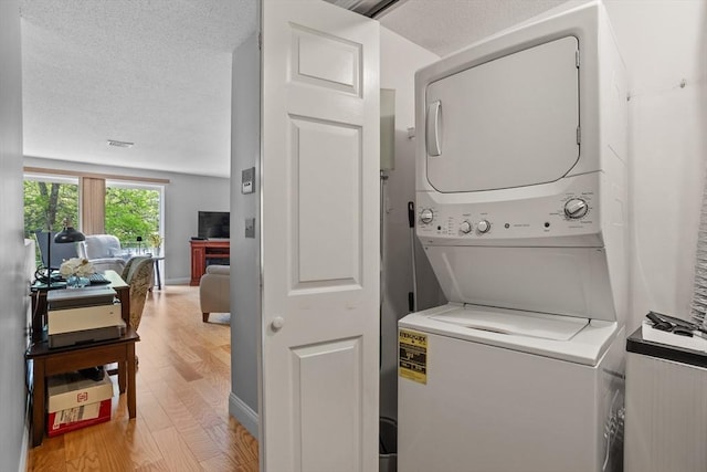 181 Littleton Rd Unit 333, Chelmsford, MA 01824 - laundry area with estacked washer and dryer, light wood-type flooring, and a textured ceiling