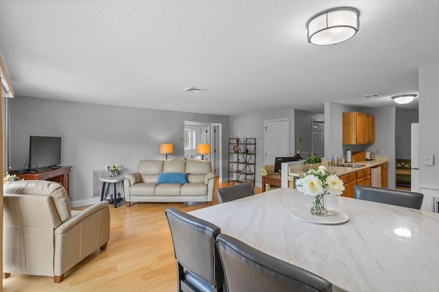 181 Littleton Rd Unit 333, Chelmsford, MA 01824 - dining room featuring light wood finished floors, baseboards, and a textured ceiling