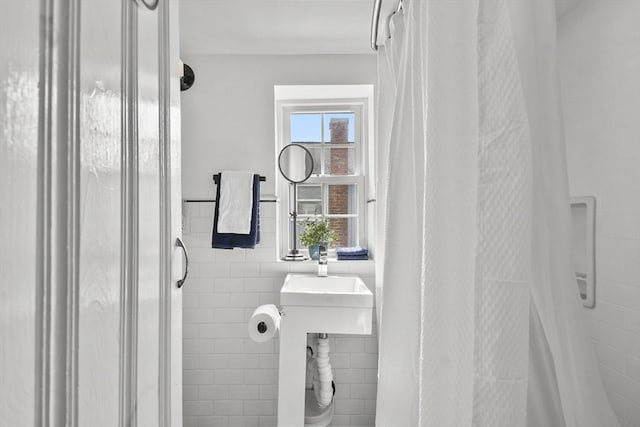full bathroom with tile walls and a stall shower