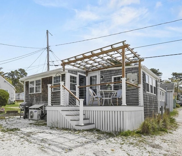 rear view of house with a pergola and a wooden deck
