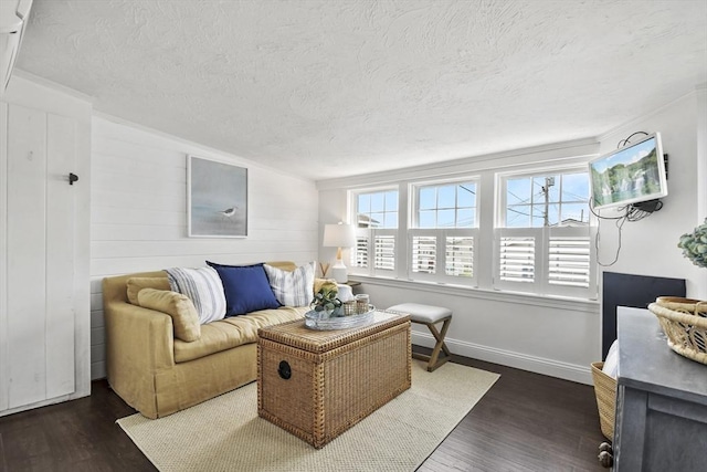 living room featuring dark wood-style flooring, a textured ceiling, and baseboards