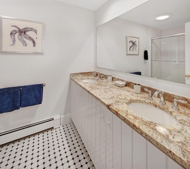 bathroom with a shower with door, vanity, and a baseboard heating unit